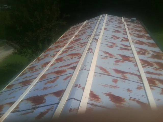 Rusted metal roof panels with new wood purlins before replacement — Storm Damage Roof Repair in Delhi by Roofing Brothers